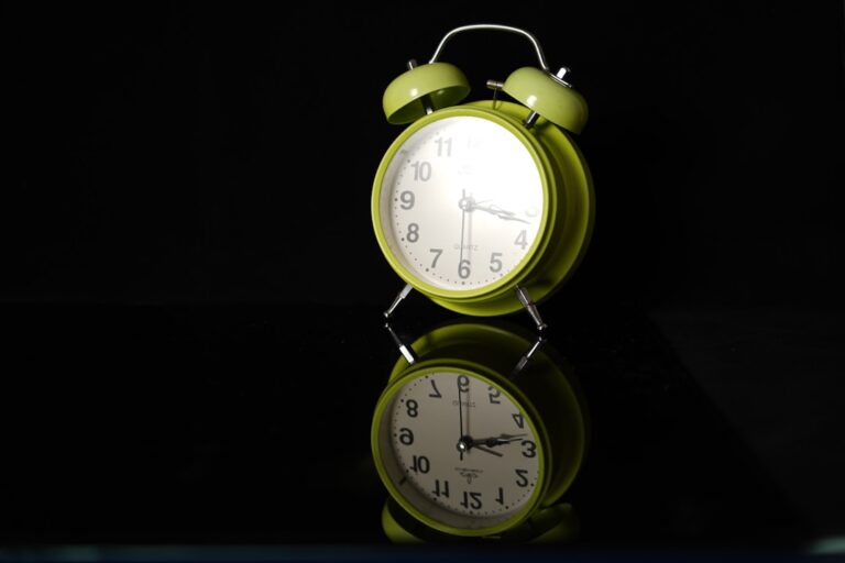 a green alarm clock sitting on top of a table