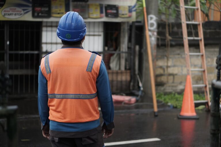 a man in an orange vest and a blue helmet