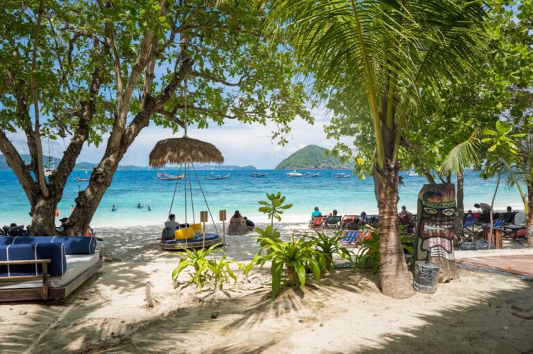 a sandy beach with people sitting under umbrellas